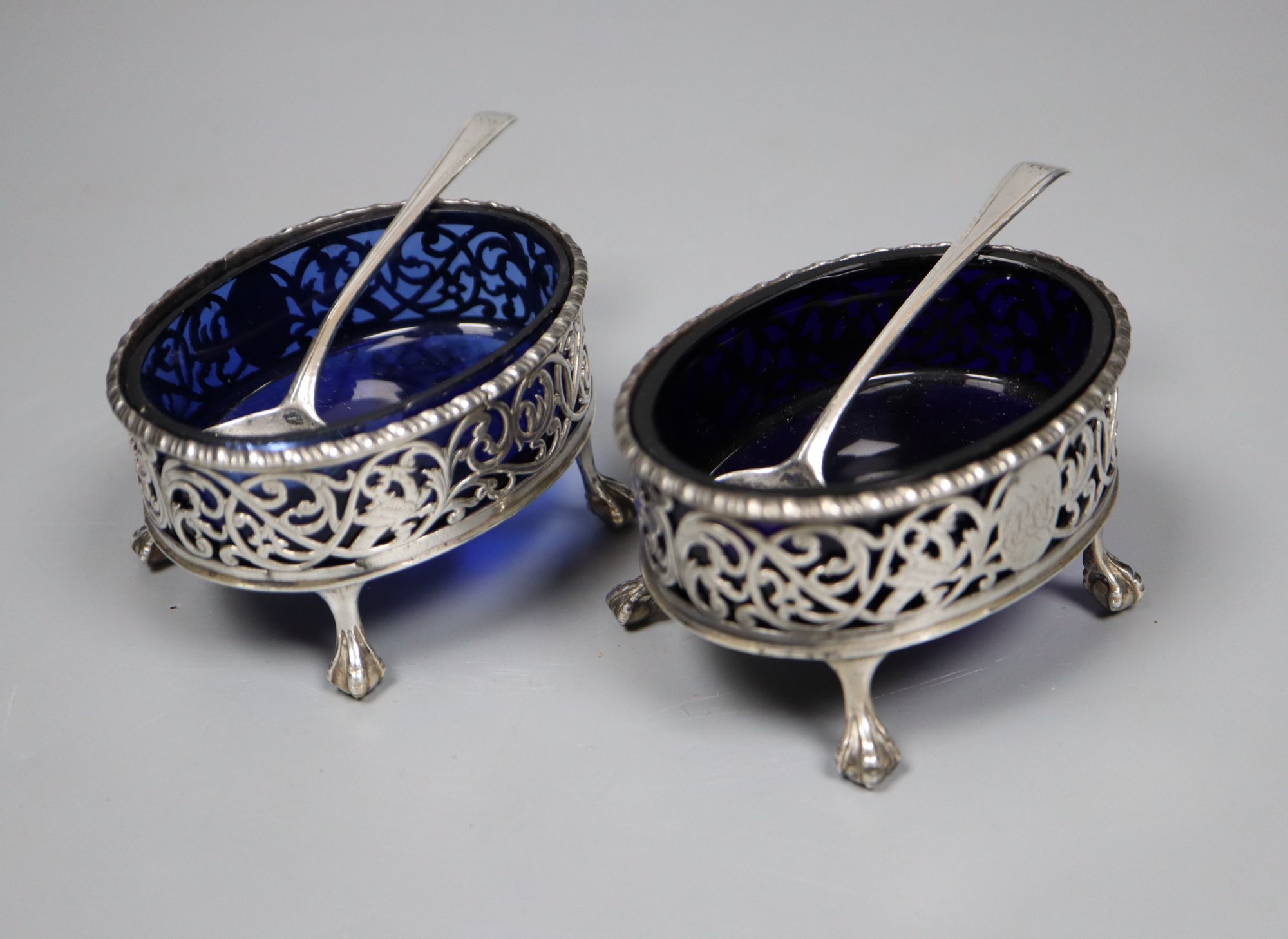 A pair of George III pierced silver oval salts, Robert Hennell I, London, 1773, 81mm and a pair of associated spoons,